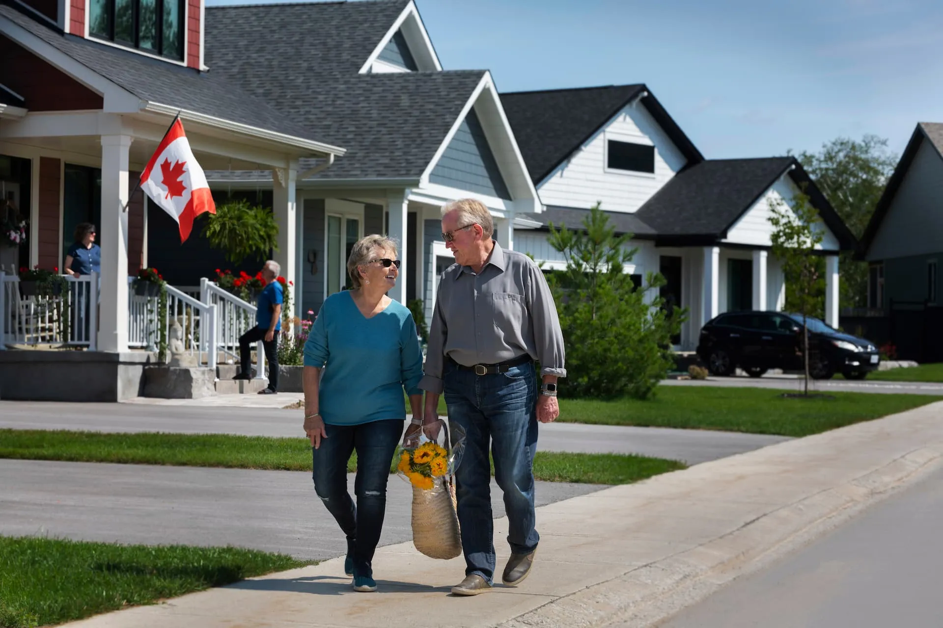 Two Watercolour residents holding a bag of flowers together, walking down the street.