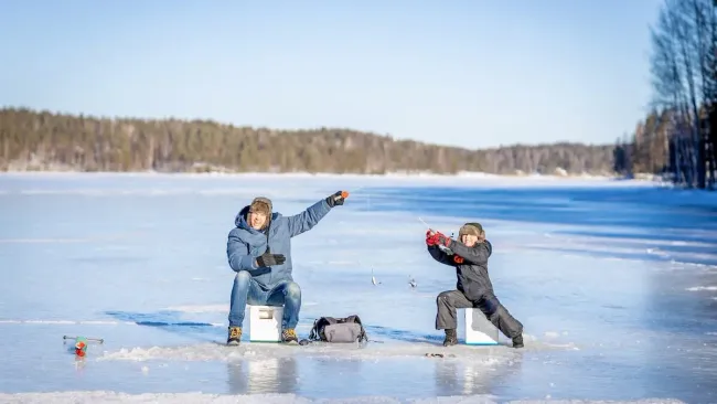 A father and son ice fishing near Westport, Ontario.
