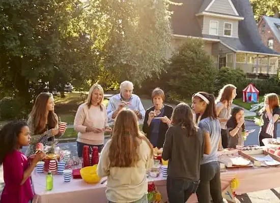 A community having a neighbourhood BBQ on the street.