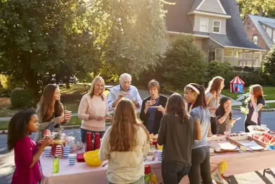 A community having a neighbourhood BBQ on the street.