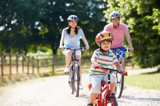 A family of 3 cycling near Watercolour Westport.