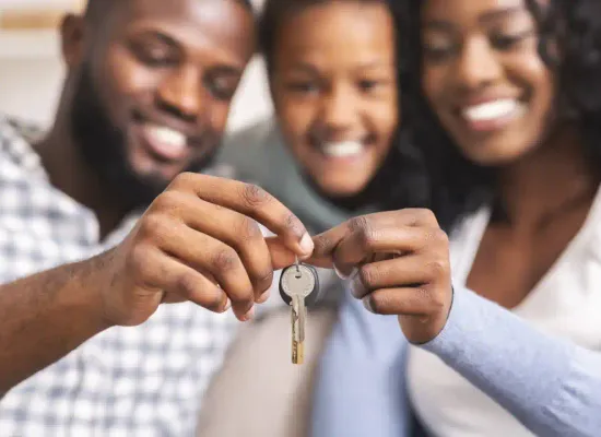 A young family holding the keys to their new home.
