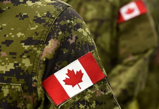 A soldier with a Canadian flag patch on their arm.