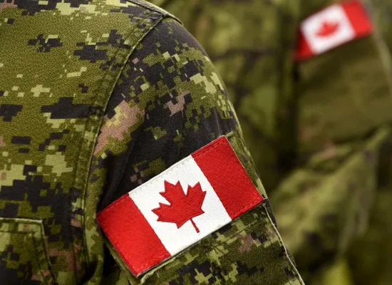 A soldier with a Canadian flag patch on their arm.