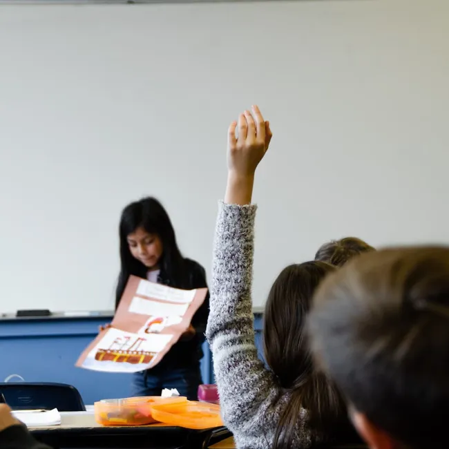 A gilr asking a question in class.