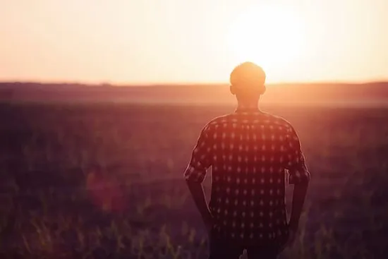 A man looking off into the sunset.